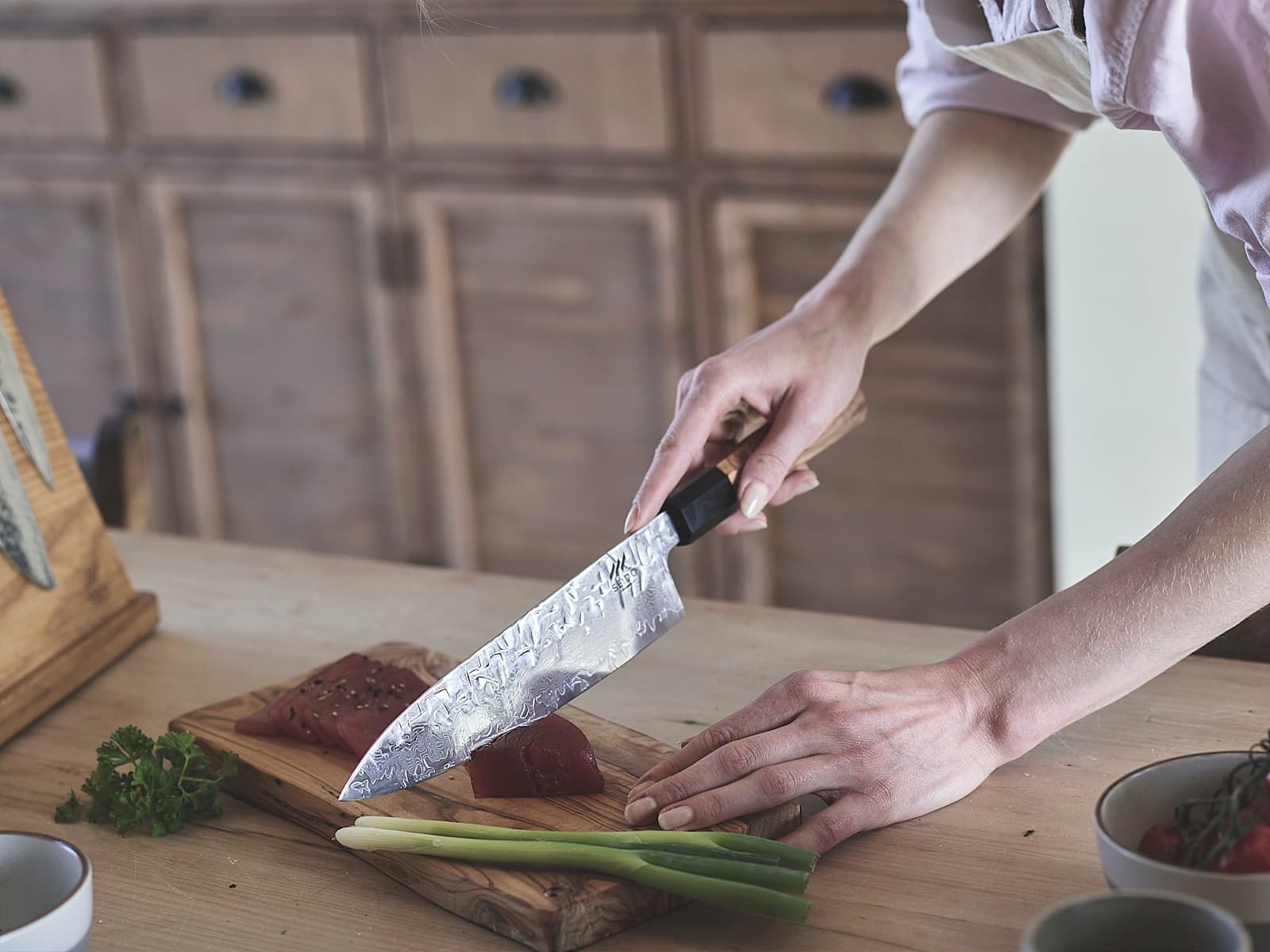 The layered pattern of the SEIDO chef's knife blade, slicing tuna