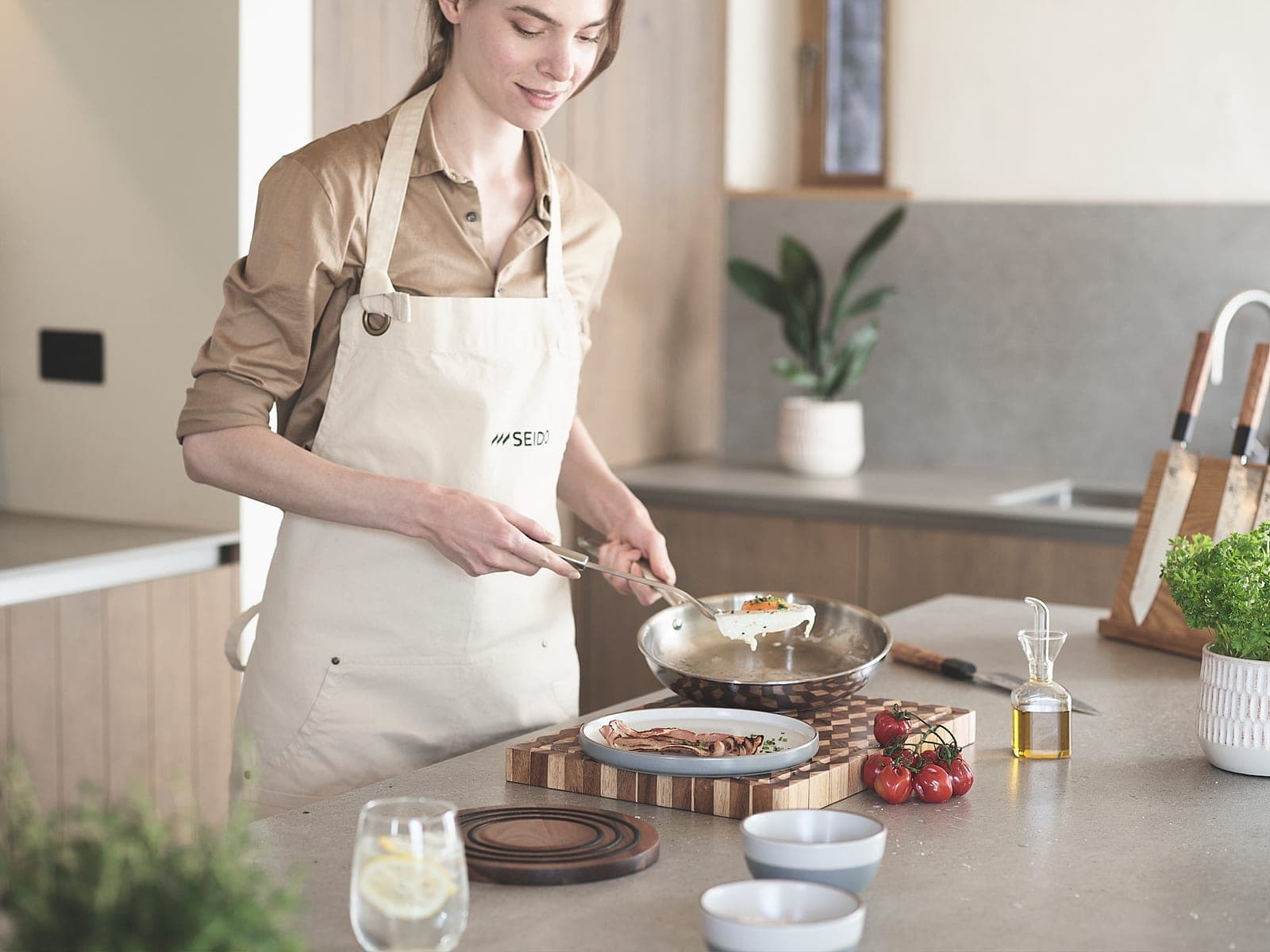 Plating a meal straight from an uncoated stainless steel frying pan in a bright kitchen