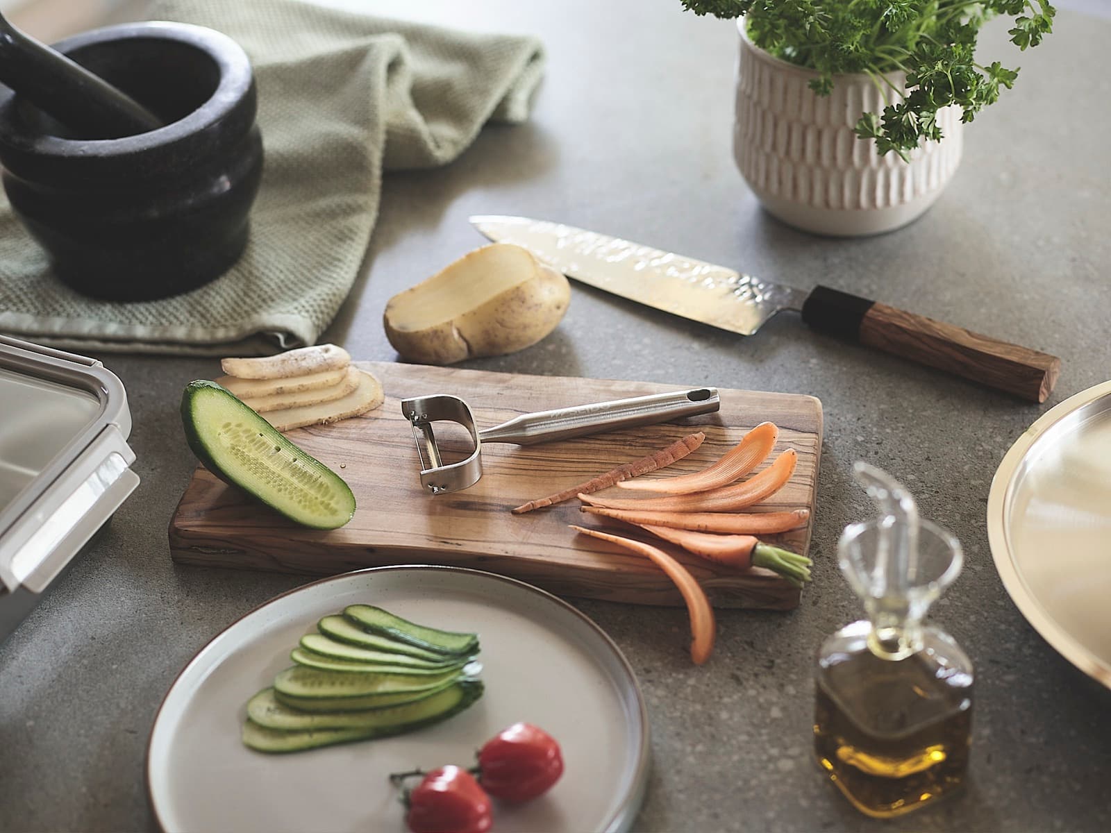 SEIDO serrated peeler and chef's knife on a kitchen worktop beside peeled carrot and cucumber