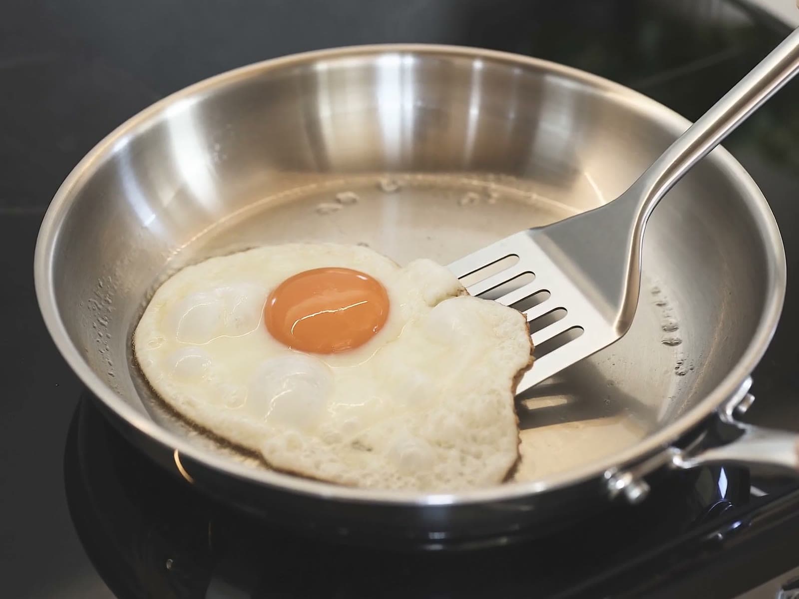 Home cook with a SEIDO stainless steel pan in a bright kitchen